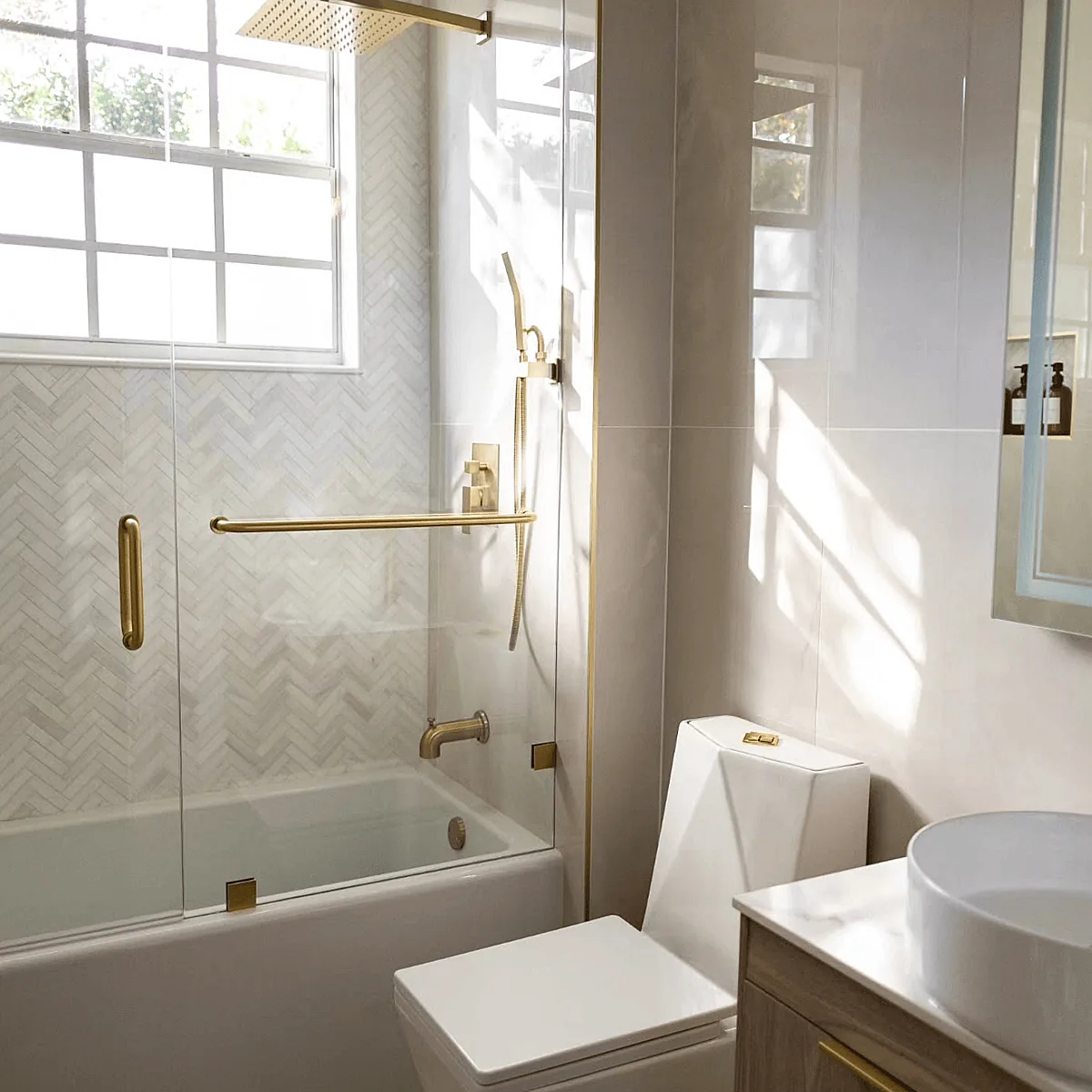Herringbone tile tub surround with brass fixtures
