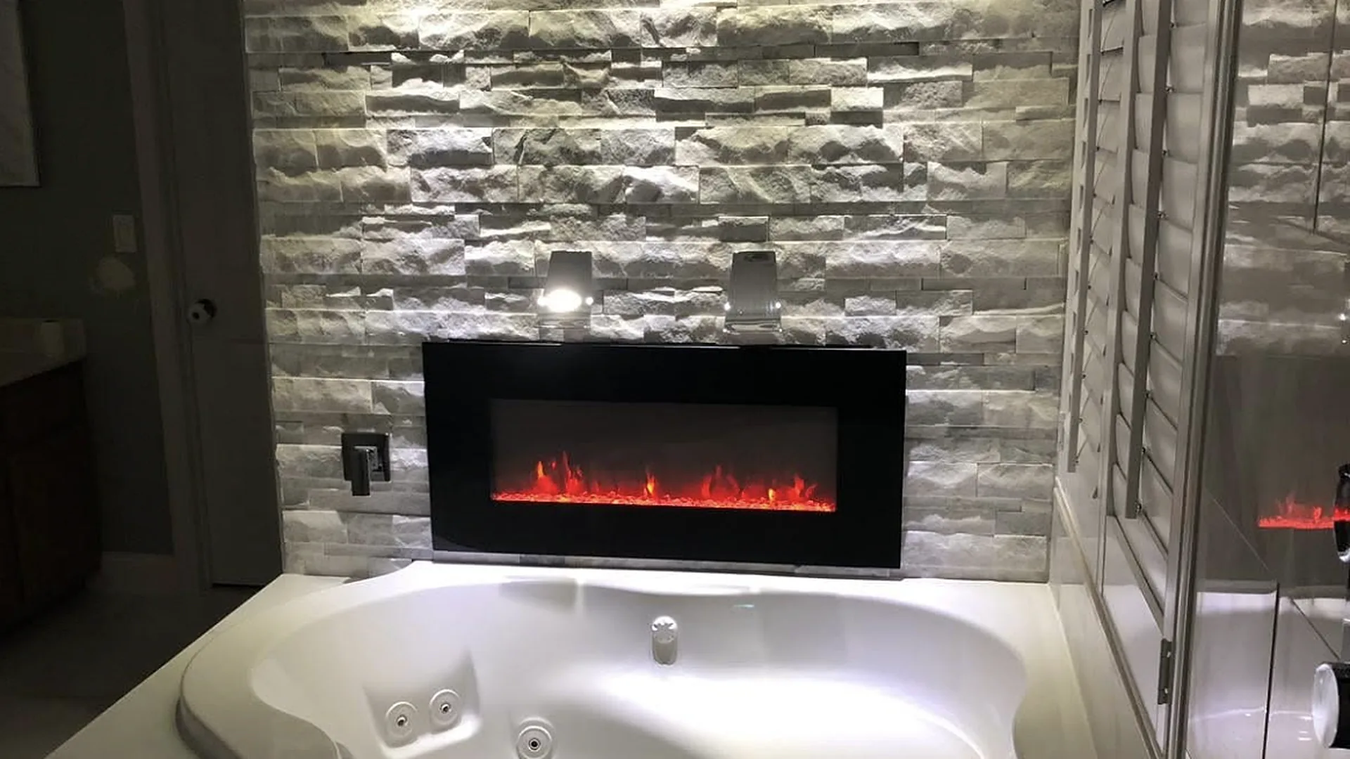 Spa tub, stone feature wall and fireplace in a bathroom remodel by A M Tile Renovations, Orlando FL