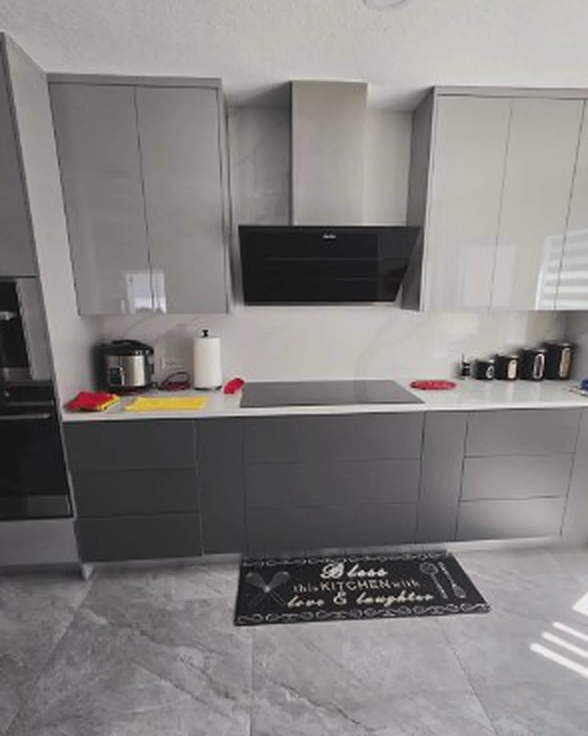 Modern grey kitchen with handleless cabinets and marble-look floor tile