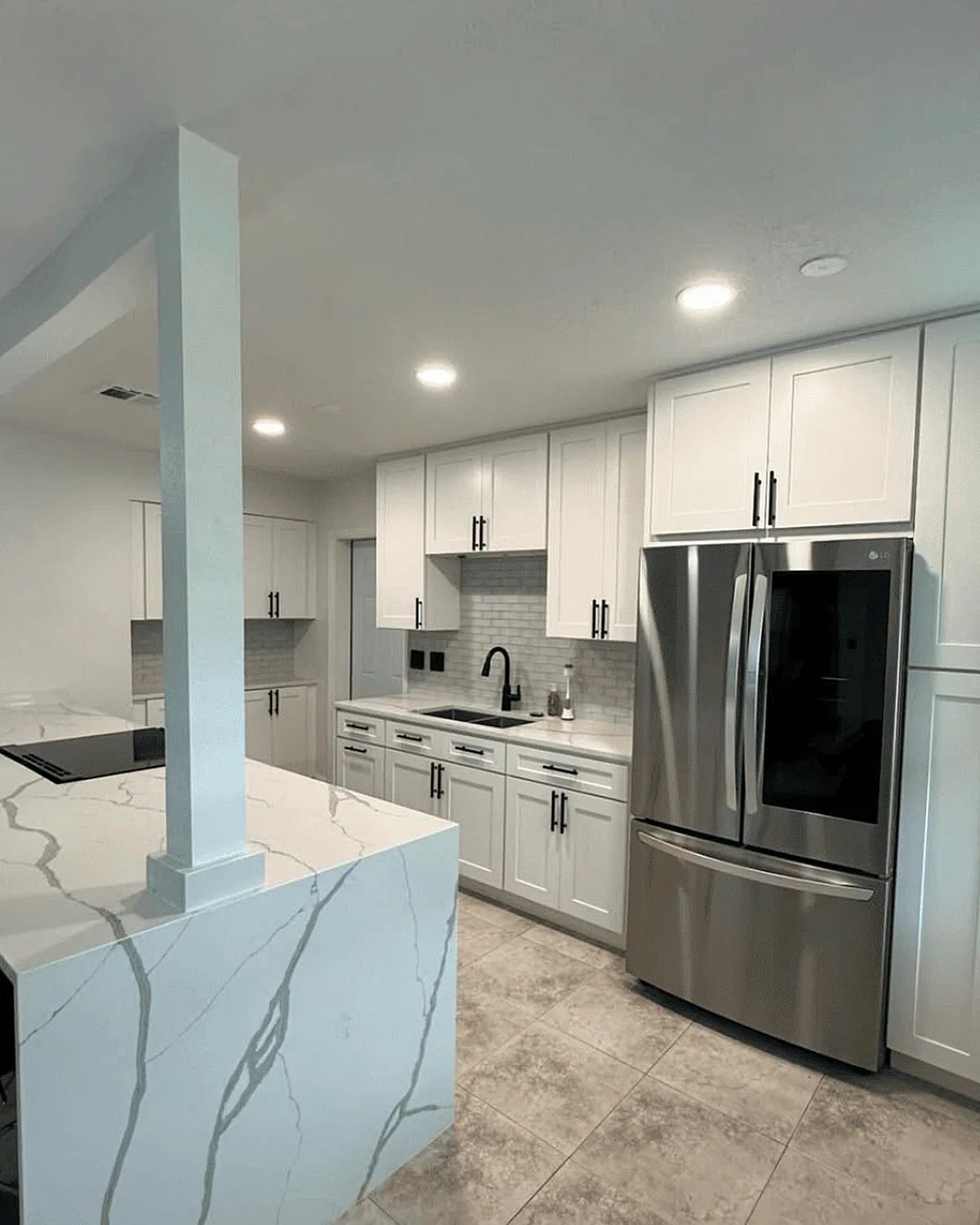 White kitchen remodel with a quartz waterfall island
