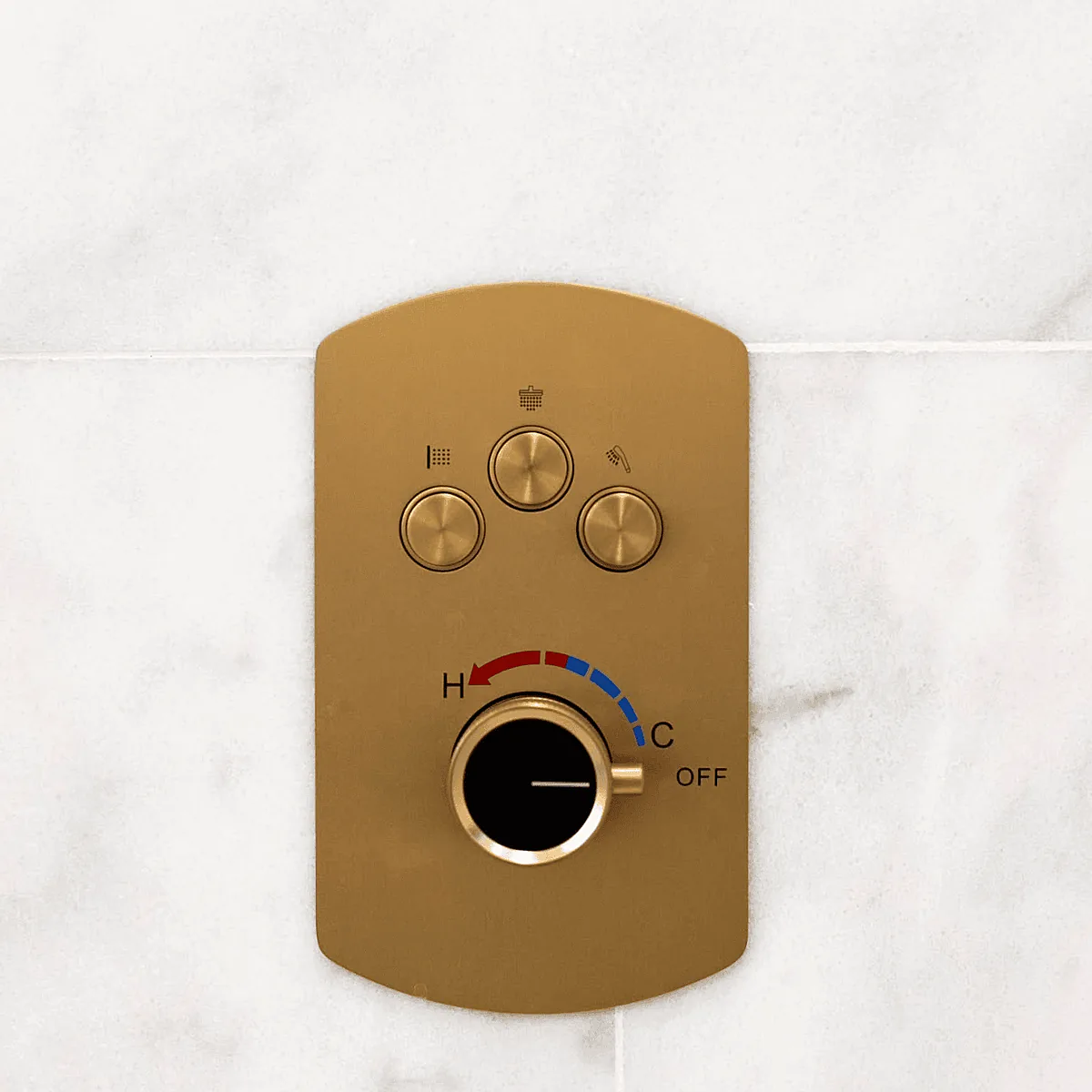 Brushed gold shower control valve on marble tile
