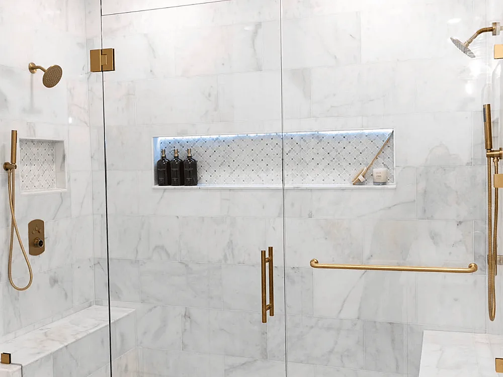 Marble shower with brass fixtures and a built-in niche